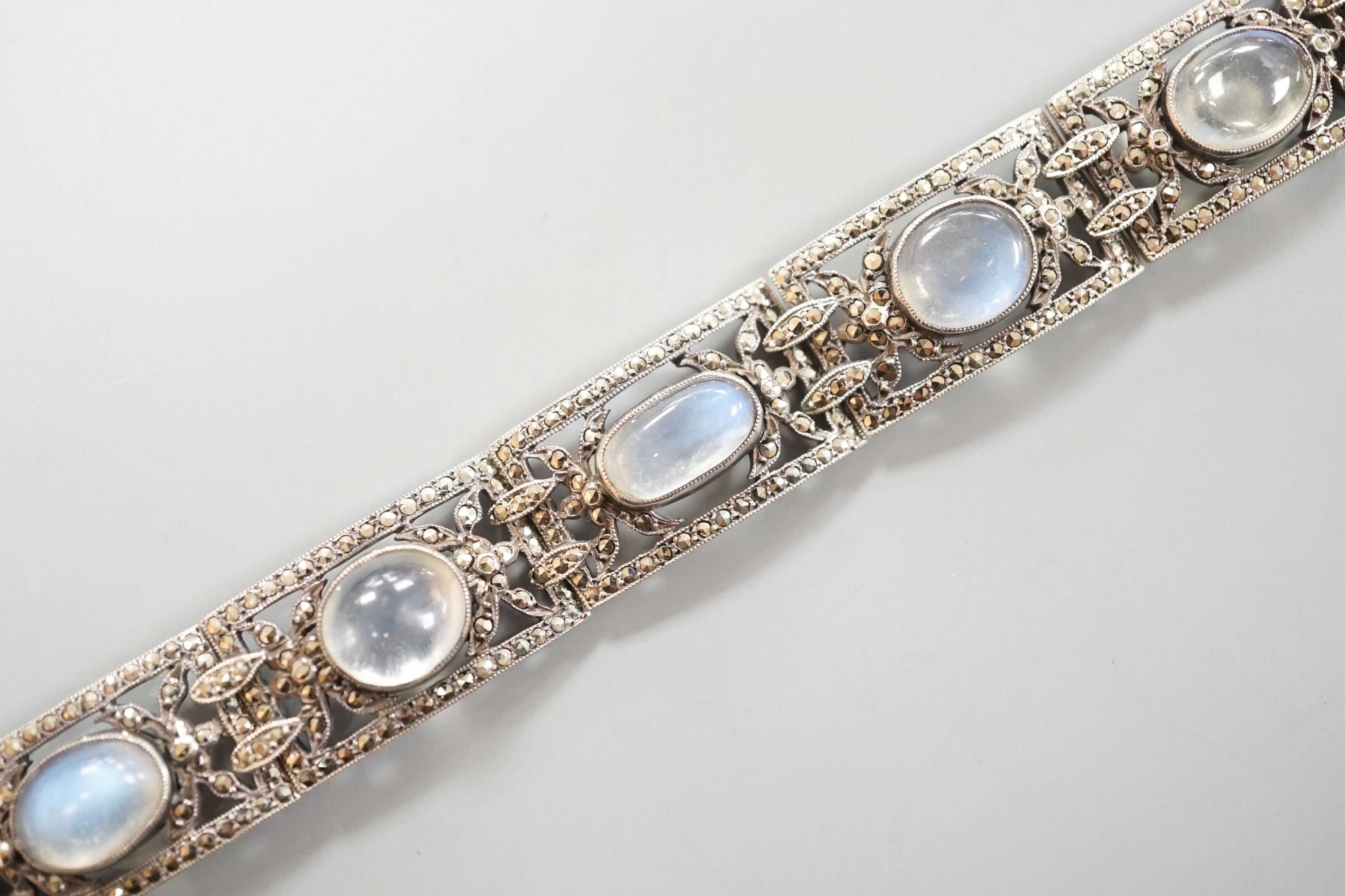 An early 20th century white metal, nine stone cabochon moonstone and marcasite set bracelet, 17.2cm.